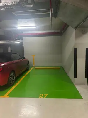 a parking garage with a red car parked in it at Emerald Luxury Suite DMCC Metro station in Dubai