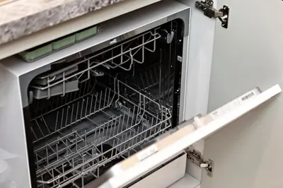a dishwasher with its door open with dishes in it at Stylish 1BR Apartment at Damac Hills Golf Gate in Dubai