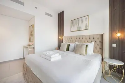 a bedroom with a large white bed and a table at Mahogany 21 - 4BR - Dubai Mall Walk & Burj Khalifa in Dubai