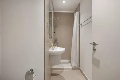 a white bathroom with a sink and a shower at Mahogany 21 - 4BR - Dubai Mall Walk & Burj Khalifa in Dubai