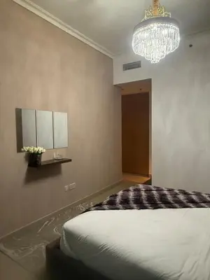 a bedroom with a large bed and a chandelier at Central Downtown 1BR - Walk to Dubai Mall in Dubai