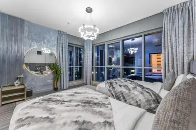 a bedroom with a white couch and a large window at Downtown Dubai 1BR - 2BR Full Burj Khalifa View in Dubai