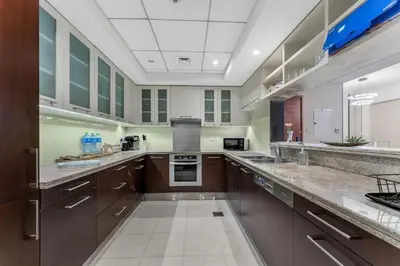 a large kitchen with wooden cabinets and stainless steel appliances at Downtown Dubai 1BR - 2BR Full Burj Khalifa View in Dubai