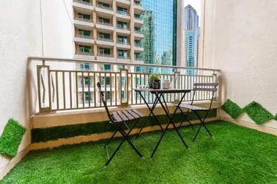 a table and two chairs on a balcony with green grass at Downtown Dubai 1BR - 2BR Full Burj Khalifa View in Dubai