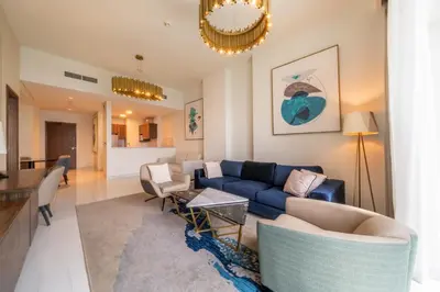 a living room with a blue couch and a table at Prestige Heights 1BR with Iconic Oceanview in Dubai