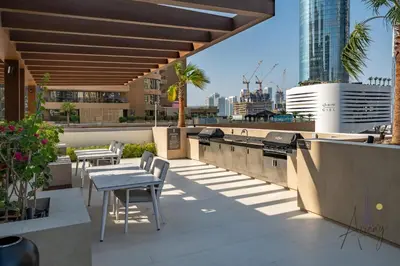 a rooftop patio with tables and chairs on a building at Luxe 2BR Maid High Floor LIV Marina Dream in Dubai