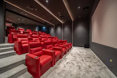 a cinema room with red chairs and a screen at Luxury Modern 1BR Paragon by Igo Downtown 1BR in Dubai
