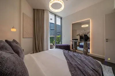 a bedroom with a white bed and a large window at Luxury Modern 1BR Paragon by Igo Downtown 1BR in Dubai
