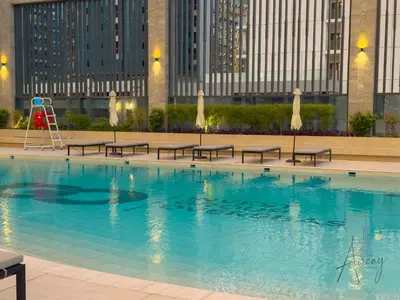 a swimming pool with benches and a playground at Luxury 1BR Paragon by IGO BURJ khalifa View in Dubai