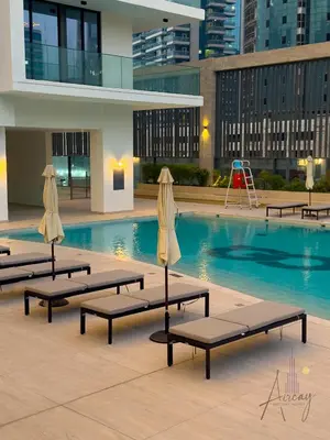 a swimming pool with chaise lounges in a building at Luxury 1BR Paragon by IGO BURJ khalifa View in Dubai