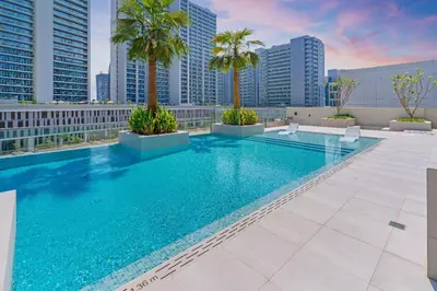 a swimming pool on the roof of a building with palm trees at Sleek & Glam Downtown Studio Near Burj Khalifa in Dubai