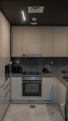 a kitchen with a stove and white cabinets at Upscale 1BR Paragon by IGO Near Downtown in Dubai