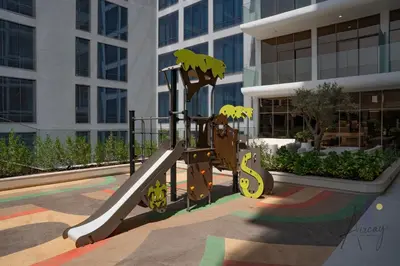 a playground in front of a building with a slide at Boutique 1BR Escape Cosy & Classy JVC in Dubai