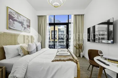 a bedroom with a bed and a desk and a window at Bloomfields Modern STU Azizi Riviera in Dubai