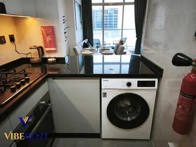 a kitchen with a washing machine and a stove at Supreme joy in Arjan 1 BHK in Dubai