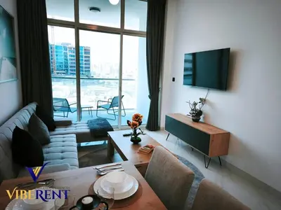 a living room with a couch and a tv at Supreme joy in Arjan 1 BHK in Dubai