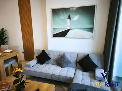 a living room with a couch and a picture of a lighthouse at Supreme joy in Arjan 1 BHK in Dubai