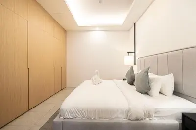 a bedroom with a large bed with white sheets at Luxe Royal Amwaj Palm Jumeirah Beach Access in Dubai