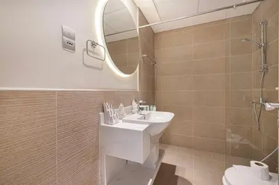 a bathroom with a sink and a mirror and a shower at Swanky Studio with Balcony in Dubai Hills Estate in Dubai