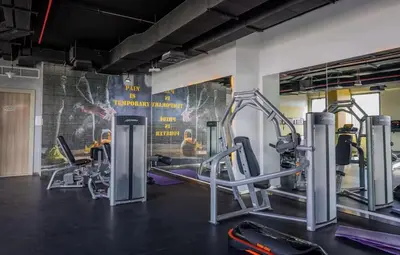 a gym with several tread machines and a mural at Swanky Studio with Balcony in Dubai Hills Estate in Dubai