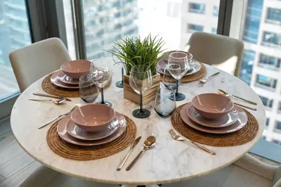 a table with plates and wine glasses on it at Modern 1BR in Dubai Marina near to Dubai Harbour in Dubai