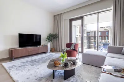 a living room with a tv and a couch and a table at Frank Porter - Grove at Creek Beach Building in Dubai
