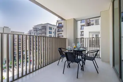 a balcony with a table and chairs on it at Frank Porter - Grove at Creek Beach Building in Dubai