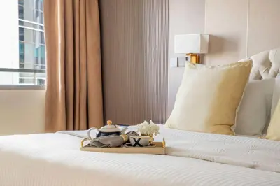a bed with a tray with a tea set on it at Frank Porter - Ocean Heights, Dubai Marina in Dubai
