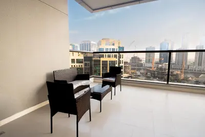 a balcony with chairs and a table and a large window at Escape24 2BR with Large Balcony near Burj Khalifa in Dubai