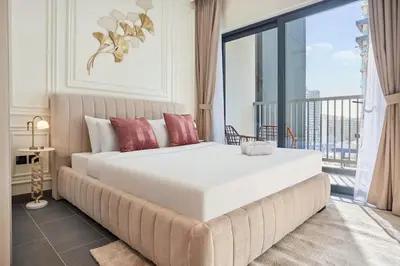 a bedroom with a large white bed and a balcony at The Crest C Luxury Retreat Stylish & Serene in Dubai
