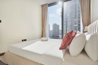 a large white bed in a room with a large window at The Crest C Luxury Retreat Stylish & Serene in Dubai