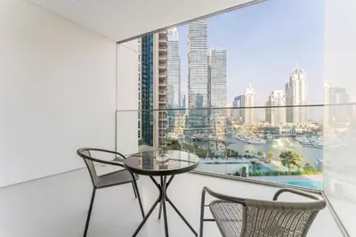 a balcony with a glass table and two chairs at Luxury 1BR with Pool and Stunning Marina Views, Perfectly Located Minutes from the Beach, Tram, and Mall, LIV Marina, Dubai Marina by Deluxe Holiday Homes in Dubai