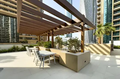 a patio with tables and chairs on a building at Luxury 1BR with Pool and Stunning Marina Views, Perfectly Located Minutes from the Beach, Tram, and Mall, LIV Marina, Dubai Marina by Deluxe Holiday Homes in Dubai
