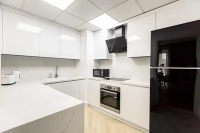 a white kitchen with white cabinets and a counter top at Stylish 1 Bedroom Apartment with Marina View JBR in Dubai