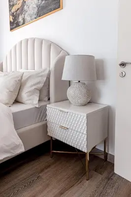 a lamp on a night stand next to a bed at Beautiful 2 bed in JBR! bahar in Dubai