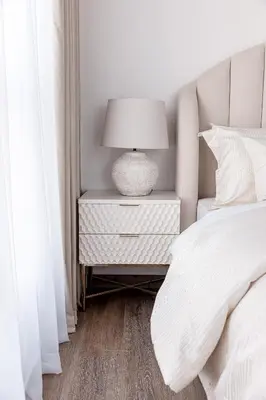 a white bedroom with a bed and a lamp on a night stand at Beautiful 2 bed in JBR! bahar in Dubai