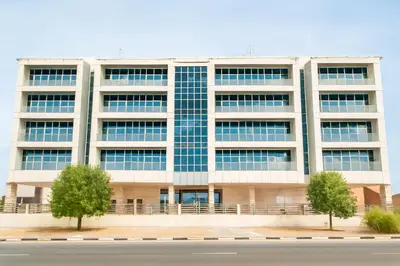 an office building with trees in front of it at City Stay Dubai South - Serviced Apartments in Dubai