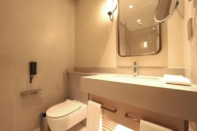 a bathroom with a toilet and a sink and a mirror at Prime Stay Elite, Dubai Mall & Burj Khalifa View in Dubai