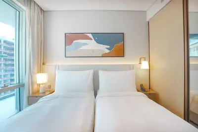 two white beds in a hotel room with a window at Prime Stay Elite, Dubai Mall & Burj Khalifa View in Dubai