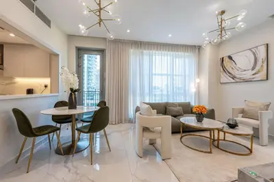 a living room with a couch and a table and chairs at 1 BR Near Burj Khalifa & Dubai Mall - Downtown in Dubai