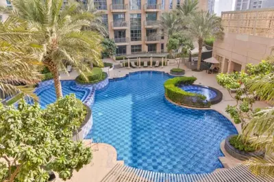 an overhead view of a large swimming pool with palm trees at 1 BR Near Burj Khalifa & Dubai Mall - Downtown in Dubai