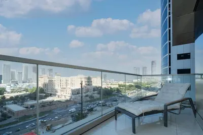 a chair on a balcony with a view of a city at Spacious 2-Bed Marina Home with Wrap-Around Balcony in Dubai