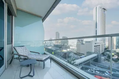 a balcony with a chair and a view of a city at Spacious 2-Bed Marina Home with Wrap-Around Balcony in Dubai
