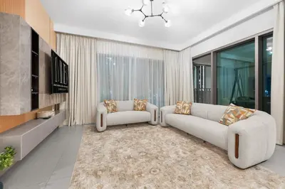 a living room with two white couches and a television at The Iconic View - 3BR With Maid's Room - Burj Khalifa Area in Dubai