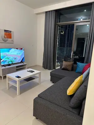 a living room with a couch and a tv at Great 1 bed apart close to Burj Khalifa and Dubai Mall in Dubai