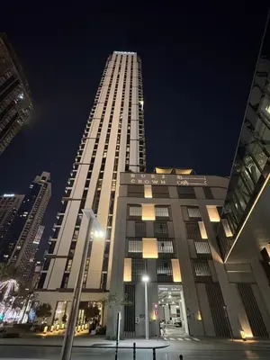 a tall building at night with lights on at Great 1 bed apart close to Burj Khalifa and Dubai Mall in Dubai