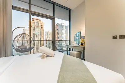 a bedroom with a bed and a large window at Luxurious High-Floor 3BR with Assistant Room, Showcasing Lake & City Views, Just Moments Drive from JBR Beaches and Ain Dubai, MBL Royal, JLT by Deluxe Holiday Homes in Dubai
