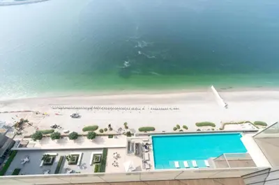 a view of a beach with a swimming pool and the ocean at Luxury 1BR with Private Beach & Pool! in Dubai