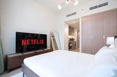a bedroom with a bed and a television on a wall at Modern Studio in Azizi Riviera 46 with Pool, Gym & Free Parking in Dubai