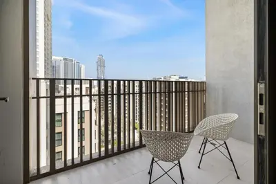 a balcony with two chairs and a view of a city at Bright 1BR with Balcony Creek Beach Access in Dubai